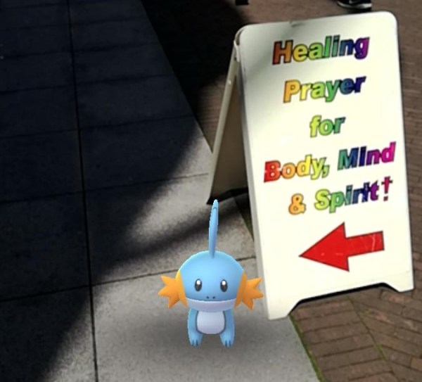 A sign advertising Healing Prayer forbody, mind & spirt that points to Mudkip.