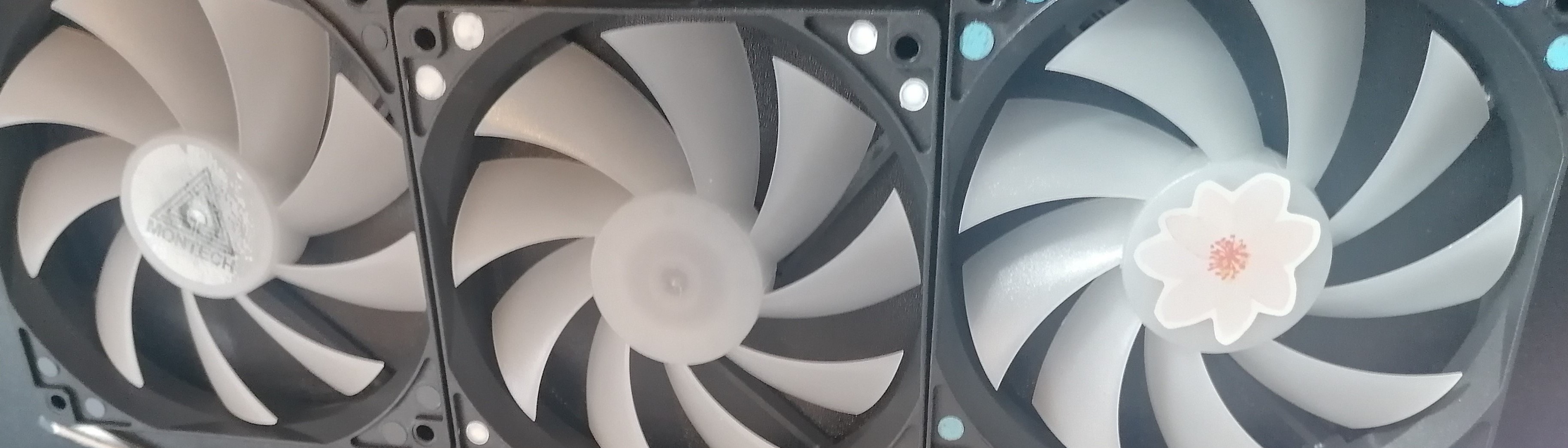 Three fans, one with a logo in the center, one clean, one with a flower sticker